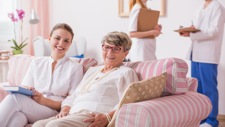 a senior lady smiling next to her caregiver