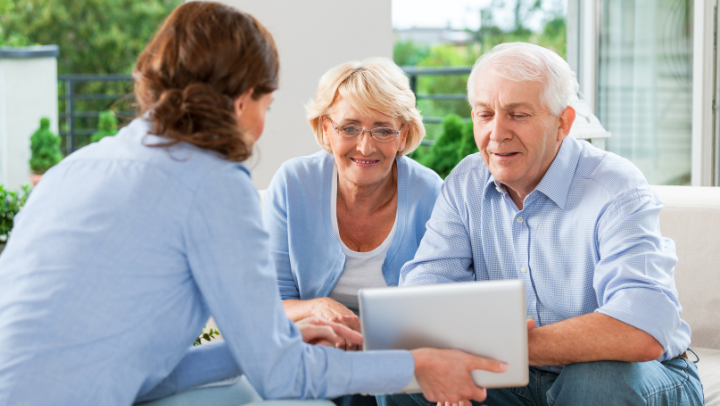 a couple of seniors reading together on a tablet